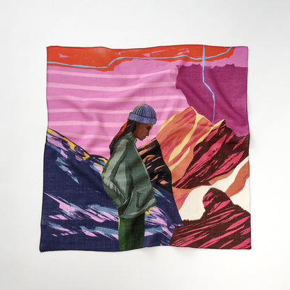 「Peak District sunset」リング付きミニスカーフの全体像。 ピンクベージュと紫の地形と山々をモチーフにした風景デザイン。中央に緑の帽子をかぶり緑のコートを着た人物のシルエットが立っている。薄手で柔らかく、繊細な仕上がりが特徴の日本製スカーフ。